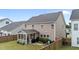A view of the back of the house shows a screened in porch and a fenced-in backyard with grassy areas at 5292 Goosecross Way, Fuquay Varina, NC 27526