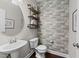 Stylish half-bathroom with wood plank accent wall, modern vanity, and a round mirror at 5292 Goosecross Way, Fuquay Varina, NC 27526