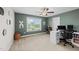 Bedroom/office features a ceiling fan, carpet, a window overlooking the lush backyard, and a functional desk at 5292 Goosecross Way, Fuquay Varina, NC 27526