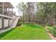 A well-manicured backyard with a lush lawn, fencing, and access to a deck through white stairs at 5410 Highcroft Dr, Cary, NC 27519