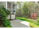 Scenic backyard showcasing a lush lawn, mature trees, and a charming screened porch at 5410 Highcroft Dr, Cary, NC 27519