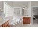 This bathroom has a window above the tub, a vanity with cabinets, and a door leading to another room at 5410 Highcroft Dr, Cary, NC 27519