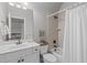Well-lit bathroom with a single sink vanity, toilet, and shower with beige tile at 5410 Highcroft Dr, Cary, NC 27519
