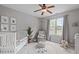 Cozy Bedroom with a white crib, decorative lion rug, and an armchair near the window at 5410 Highcroft Dr, Cary, NC 27519