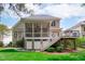 Rear exterior of house with screened porch, deck, white stairs, and lush green lawn at 5410 Highcroft Dr, Cary, NC 27519