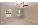 Bright bedroom with neutral carpeting, two windows, and a ceiling fan at 5410 Pageford Dr, Durham, NC 27703