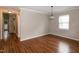 Spacious, empty room with hardwood floors, neutral paint, and a large window for natural light at 5410 Pageford Dr, Durham, NC 27703