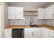Close-up of a kitchen showcasing white cabinets, butcher block countertops, and stainless steel fixtures at 5410 Pageford Dr, Durham, NC 27703