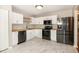 Modern kitchen featuring white cabinets, black appliances, butcher block counters, and elegant flooring at 5410 Pageford Dr, Durham, NC 27703