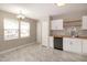 Bright kitchen and eat-in nook with white cabinets, black appliances, and marble-look flooring at 5410 Pageford Dr, Durham, NC 27703