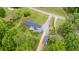 Drone shot of a home with mature trees, a new roof, a fenced yard, a deck, landscaping, and a metal outbuilding at 553 Isley Rd, Haw River, NC 27258