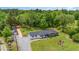 Aerial view of a single-story home with mature trees, large yard, and gravel driveway at 553 Isley Rd, Haw River, NC 27258