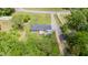 Aerial view showing fenced yard, deck, outbuilding, landscaping, and home on a large lot with mature trees at 553 Isley Rd, Haw River, NC 27258