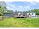View of the backyard with a deck, partial fencing, and lush green grass at 553 Isley Rd, Haw River, NC 27258