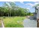 Large backyard with a wooden deck, lush lawn, and a gravel path on the side at 553 Isley Rd, Haw River, NC 27258