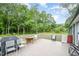 Wooden deck with outdoor seating, grill, and a view of the wooded backyard at 553 Isley Rd, Haw River, NC 27258