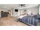 Main bedroom featuring a ceiling fan, wood floors, TV, and sliding barn door leading to other rooms at 553 Isley Rd, Haw River, NC 27258