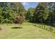 Large fenced backyard with mature trees and landscaping offers privacy and space for outdoor activities at 64 Red House Rd, Smithfield, NC 27577