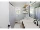 Well-lit bathroom with a modern sink, toilet, wood shelves, and a shower with a patterned curtain at 64 Red House Rd, Smithfield, NC 27577