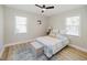 Bright bedroom with a patterned rug, ceiling fan, and ample natural light from the two windows at 64 Red House Rd, Smithfield, NC 27577