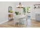 Bright dining area featuring a modern chandelier, white table, and a sliding door leading to the outdoor deck at 64 Red House Rd, Smithfield, NC 27577
