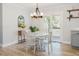 Bright dining area featuring a modern chandelier, white table, and a sliding door leading to the outdoor deck at 64 Red House Rd, Smithfield, NC 27577