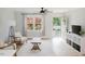 Bright living room featuring a ceiling fan, large window, and fresh paint at 64 Red House Rd, Smithfield, NC 27577