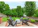 Backyard with a cozy patio featuring Adirondack chairs and a fire pit, perfect for outdoor gatherings at 729 Mills St, Raleigh, NC 27608