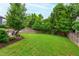Expansive backyard with a lush lawn, mature trees, and an outdoor kitchen area with a grill at 729 Mills St, Raleigh, NC 27608