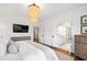 Spacious bedroom with a decorative chandelier, flat screen tv, windows, and an en-suite bathroom at 729 Mills St, Raleigh, NC 27608