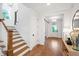 Inviting hallway with hardwood floors, wooden stairs, white trim, and a view of the front door at 729 Mills St, Raleigh, NC 27608