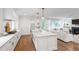 Open-concept kitchen with a white island that overlooks a beautifully lit living area at 729 Mills St, Raleigh, NC 27608