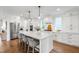 Bright kitchen features a large island with seating, white cabinets, and wood floors at 729 Mills St, Raleigh, NC 27608
