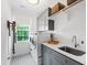 Well-lit laundry room with gray cabinets, white subway tile backsplash, and front load machines at 729 Mills St, Raleigh, NC 27608