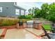 Brick outdoor kitchen area with a built-in grill, stainless steel storage, and bar seating at 729 Mills St, Raleigh, NC 27608