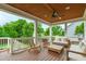 Covered porch area with wood ceiling, ceiling fan, railings, and outdoor furniture for relaxing at 729 Mills St, Raleigh, NC 27608