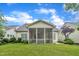 View of the backyard showcasing the screen porch, lush lawn, and manicured landscaping at 79 Heatherwood Dr, Chapel Hill, NC 27516