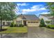 Charming home boasts manicured lawn, two-car garage, and inviting curb appeal on a sunny day at 79 Heatherwood Dr, Chapel Hill, NC 27516