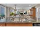 Gourmet kitchen featuring an island with granite countertop, stainless sink, and views of the living room at 79 Heatherwood Dr, Chapel Hill, NC 27516