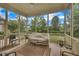 Inviting screened porch with comfortable seating, ceiling fan, and views of the lush backyard landscaping at 79 Heatherwood Dr, Chapel Hill, NC 27516