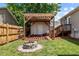Inviting backyard features a pergola-covered area, storage shed, and a cozy fire pit for gatherings at 800 Linens St, Graham, NC 27253