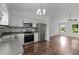 Bright kitchen featuring stainless steel appliances, white cabinets, a stylish backsplash, and seamless living room view at 800 Linens St, Graham, NC 27253