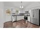 Modern kitchen with stainless steel appliances, white cabinetry, stylish backsplash, and hardwood floors at 800 Linens St, Graham, NC 27253