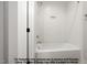 Clean bathroom featuring a white tiled shower and tub combination with a convenient inset shelf at 8021 Bud Morris Rd, Wake Forest, NC 27587
