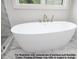 Close up of a luxurious bathroom with a soaking tub and marble tile at 8021 Bud Morris Rd, Wake Forest, NC 27587