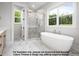 Luxurious bathroom with a soaking tub, glass-enclosed shower, and marble tile, creating a spa-like retreat at 8021 Bud Morris Rd, Wake Forest, NC 27587