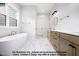 Bathroom with soaking tub, double vanities, marble countertops, and modern fixtures at 8021 Bud Morris Rd, Wake Forest, NC 27587