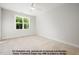 Bright bedroom featuring a large window with green outdoor views, carpeted floor, and neutral wall colors at 8021 Bud Morris Rd, Wake Forest, NC 27587