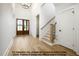 Spacious entryway featuring hardwood floors, wooden staircase, and wooden double doors at 8021 Bud Morris Rd, Wake Forest, NC 27587