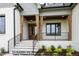 Inviting entrance with stone steps, wood columns, and dark window and railing accents at 8021 Bud Morris Rd, Wake Forest, NC 27587